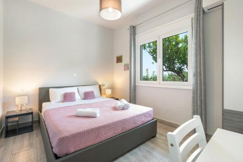 a bedroom with a bed with pink sheets and a window at 30Roses House in Sálakos