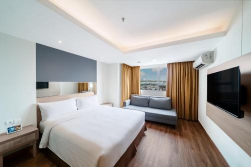 a hotel room with a large bed and a tv at ASTON Pluit Hotel & Residence in Jakarta