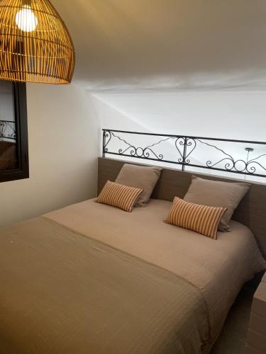 a bed with two pillows on it in a room at Jasmin et Camomille in Roquebrun