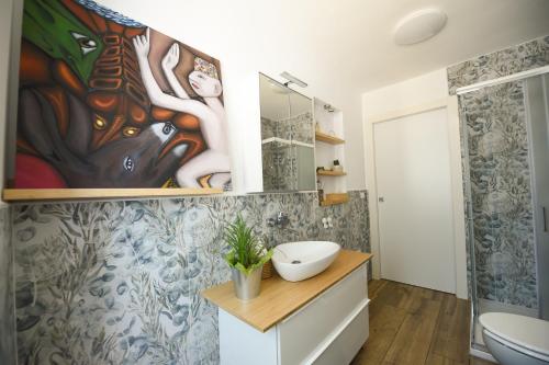 a bathroom with a painting on the wall at Casa Vacanza La Torre in Paratico