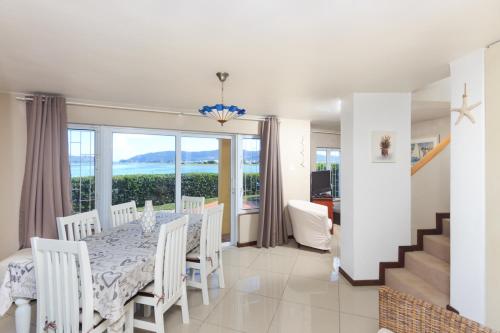 a dining room with a table and a view of the ocean at Ilse's Garden Route Gem in Knysna