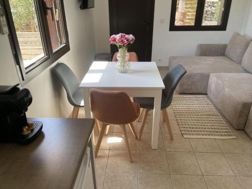 a living room with a table with a vase of flowers on it at Jasmin et Camomille in Roquebrun