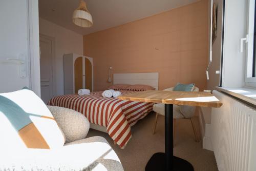 a small room with a bed and a table in it at Le Presbytère in Ambleteuse