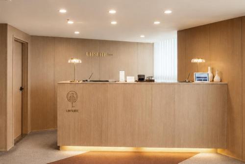 a lobby with a counter with a sign on it at UH Suite The Haeundae in Busan