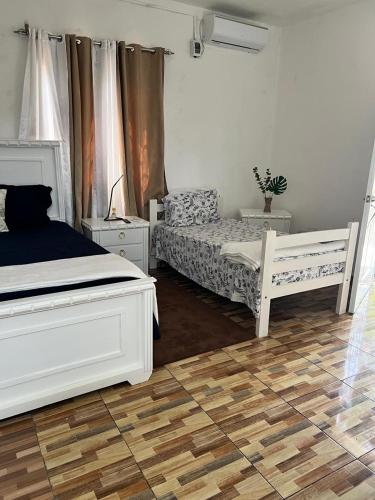 a bedroom with two white beds and a wooden floor at bon Appetit Hotel restaurant barahona in Isleta de Barahona