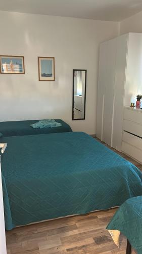 a bedroom with a bed with a green blanket at A C Tourist Accommodation in Torvaianica