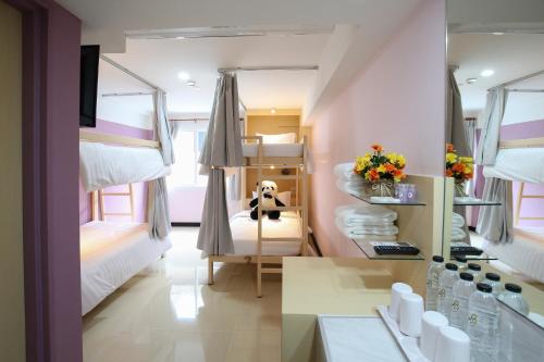 a dorm room with bunk beds and a desk and a room with atained at Lucky panda Hotel in Chiang Mai