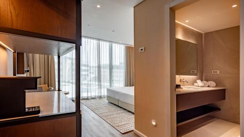 a bathroom with a bed and a sink and a mirror at Jacob Modiin in Modi'in-Maccabim-Re'ut