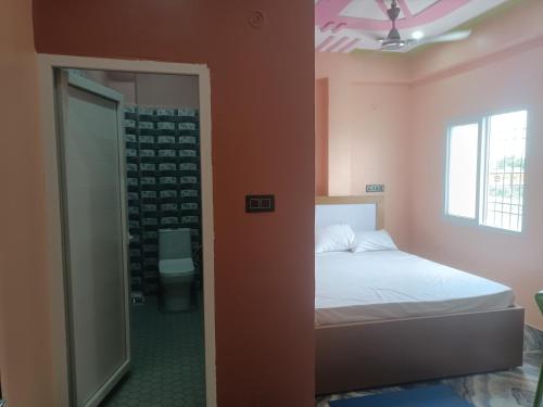 a bedroom with a bed and a walk in shower at HOTEL अtithi in Rājgīr
