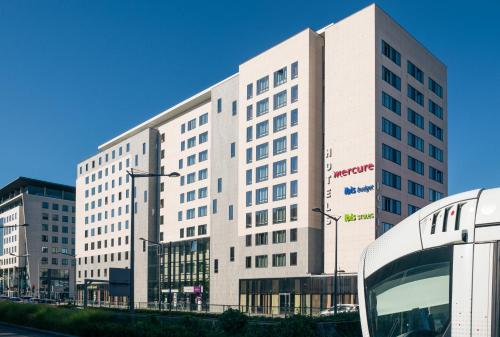 a large white building in front of a street at Ibis Budget Lyon Centre - Gare Part Dieu in Lyon