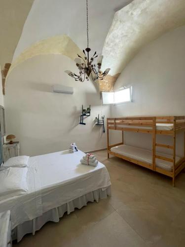 a bedroom with a bed and a chandelier at I Ricordi di Anna in Alezio