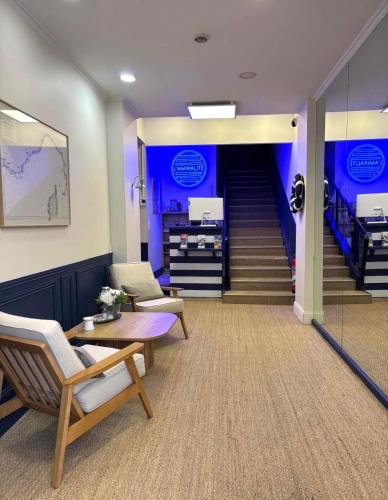 a lobby with a staircase with chairs and a table at Hotel Amiraute in Cannes
