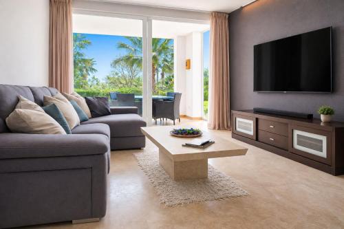a living room with a couch and a flat screen tv at The Lagoon Apartment- Free Lagoon Access in Estepona