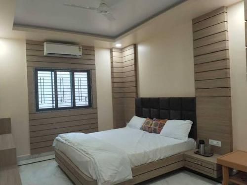 a bedroom with a large bed and a window at Hotel lakshmi in Goddā