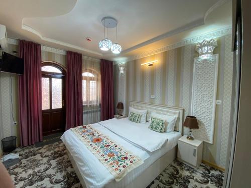 a bedroom with a large white bed in a room at El Emir in Samarkand