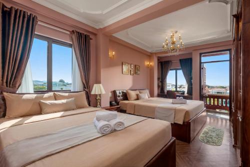 a hotel room with two beds and a balcony at Vina Classic Hotel in Hue