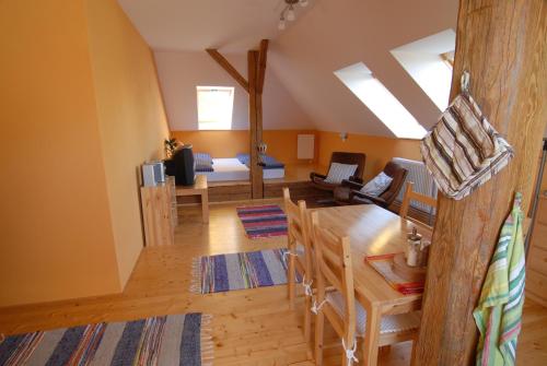 a living room with a table and a bed at Penzion Dvůr in Obora