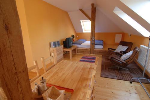 a attic living room with a bed and a couch at Penzion Dvůr in Obora