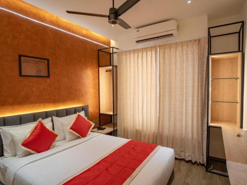 a bedroom with a large bed with red pillows at Crown Residency in Kanyakumari