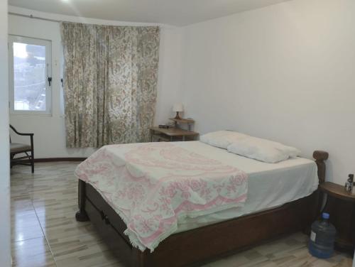 a bedroom with a bed with a pink blanket on it at Comfortable 2-Bedroom Apartment, Monte Sossego in Mindelo
