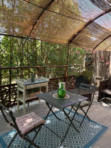 a patio with a table and chairs under a pergola at Douce escapade in Bourg-Saint-Andéol