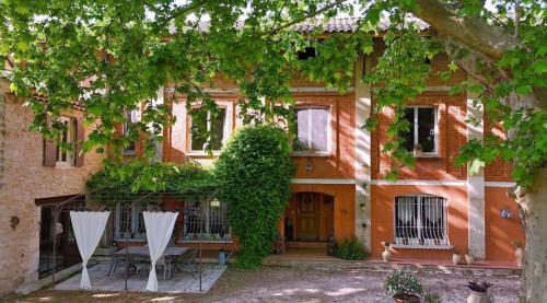 a building with a table and chairs in front of it at Douce escapade in Bourg-Saint-Andéol