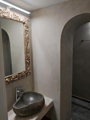 a bathroom with a stone sink and a mirror at Troulou beach house in Kimolos