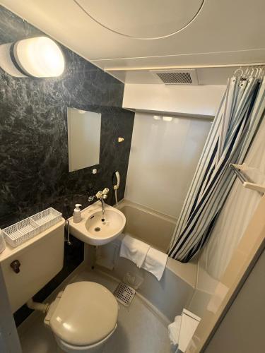a small bathroom with a toilet and a sink at アーバンホテル森下 in Tokyo