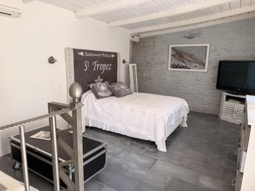 a bedroom with a bed and a flat screen tv at La Villa Fafouille in Cavalaire-sur-Mer