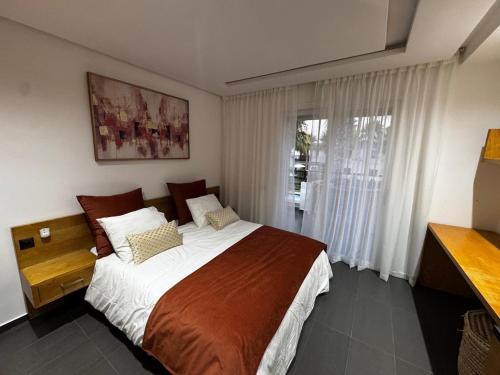 a bedroom with a large bed and a window at Villa Triplex avec piscine proche de la mer in El Harhoura