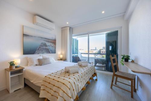 a bedroom with a large bed and a large window at Apartment Julio Pomar, swimming pool in Sagres