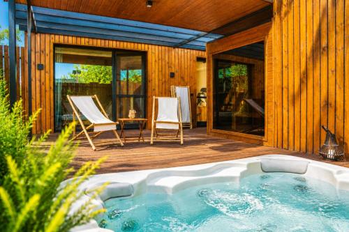 a hot tub on a deck next to a house at Natur Harmony Tiszafüred in Tiszafüred