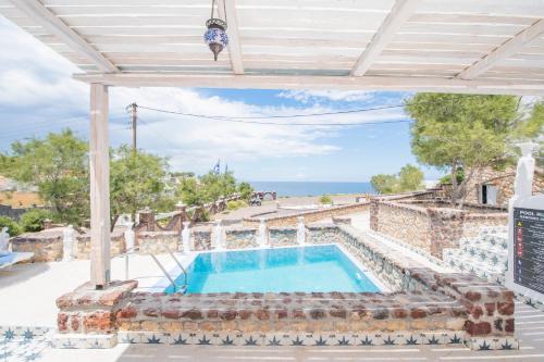 a villa with a swimming pool and the ocean at Starlight Luxury Seaside Villa & Suites in Imerovigli