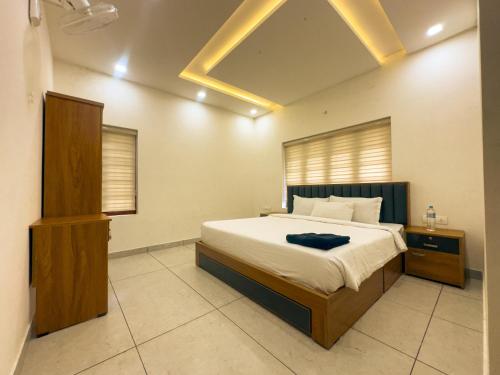 a bedroom with a large bed and a wooden cabinet at La Dimora luxury pool villa in Vythiri