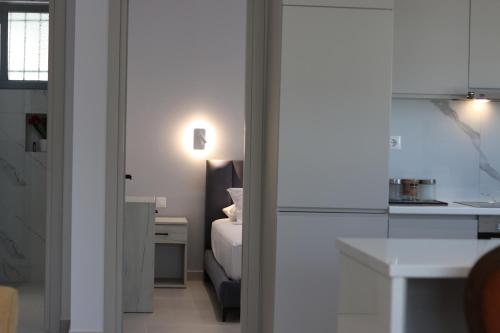 a bedroom with a bed and a kitchen with a table at Avli Rooms in Himare