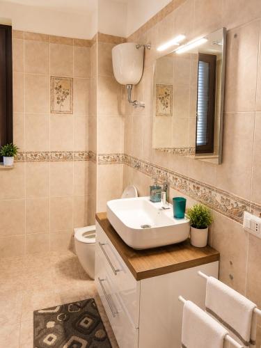 a bathroom with a sink and a toilet and a mirror at Optima Casa Vacanze II in Telese