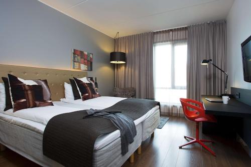 a hotel room with a large bed and a desk at Scandic Stavanger Forus in Stavanger