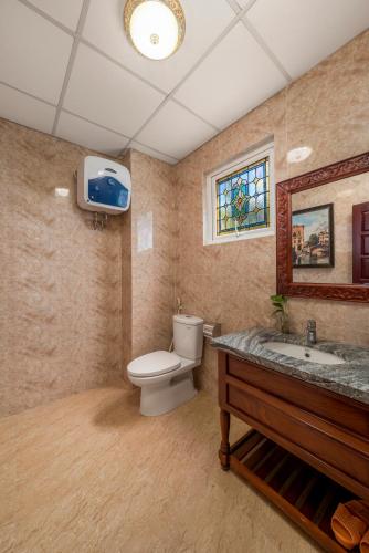 a bathroom with a toilet and a sink and a tv at Vina Classic Hotel in Hue