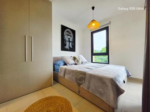 a bedroom with a bed and a window at Cozy Melody in Pirae