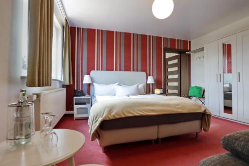 a bedroom with a large bed and a table at VITALHOTEL Schulenberg in Schulenberg im Oberharz