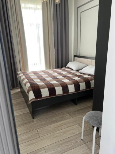 a bedroom with a bed with a mirror and a window at Коттедж Атлантис in Balykchy