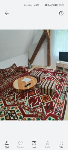 a bed with a table on top of a rug at Tinohovska vila in Hadžići