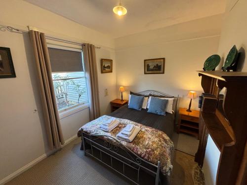 a bedroom with a bed and a large window at Robinson Cottage in Oatlands