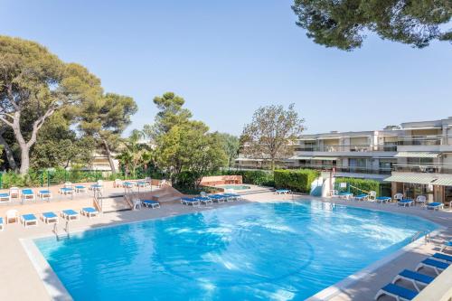 a large swimming pool with chairs and a water slide at Résidence Pierre & Vacances La Corniche d'or in Boulouris-sur-Mer