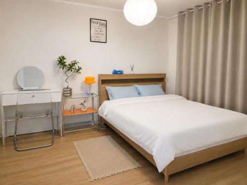 a bedroom with a bed and a table with a mirror at Herry Stay in Seoul