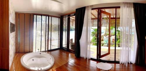 a large room with a bath tub and large windows at A-Na-Lay Resort Koh Kood in Ko Kood