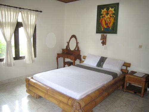 1 dormitorio con cama, mesa y ventana en Galang Kangin Bungalows 2, en Amed