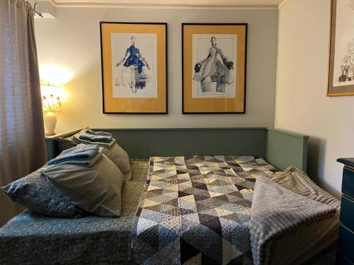 a bedroom with a bed with three pictures on the wall at Magnolia Nest in Belgrade