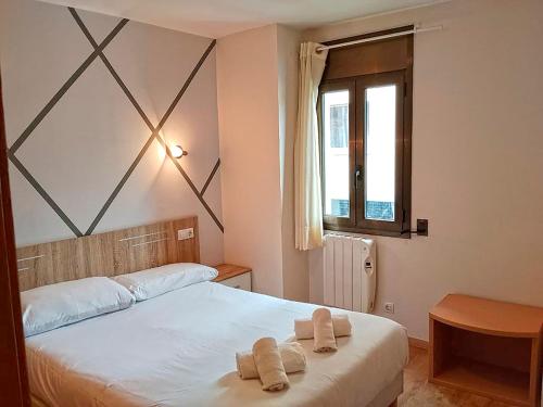a bedroom with a bed with two towels on it at Apartamentos Pantebre 3000 in Pas de la Casa