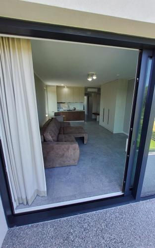 a view of a living room through a glass window at Olimp Apartamenty in Konin